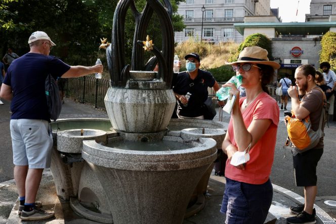 
 Orang-orang mengumpulkan air dari air mancur di Green Park di London, Inggris. 18 Juli 2022 . REUTERS/Kevin Coombs